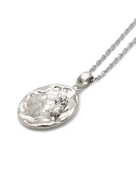 斜めから撮影して、ラッコと水面モチーフの立体感が自然に伝わるペンダントトップのアップ画像。