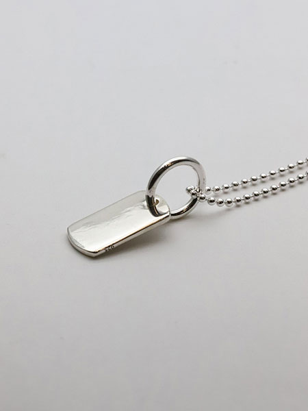 ドッグタグを横から写し、程よい厚みと大きめのバチカンが良く映える画像。