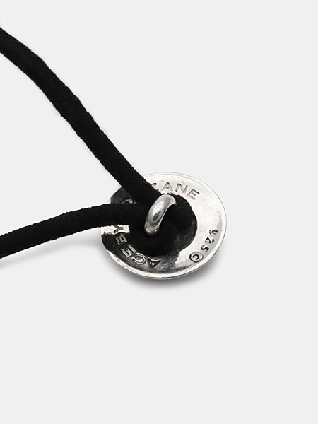 コンチョ裏面に弧を描くように施されたブランド刻印と、ループ構造が分かるアップ画像。