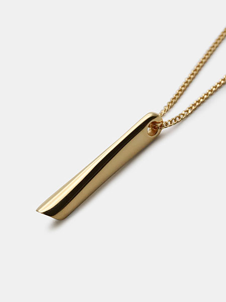 上から下にかけてわずかに広がるペンダントトップの形と、ゴールドの艶感が分かるアップ画像。